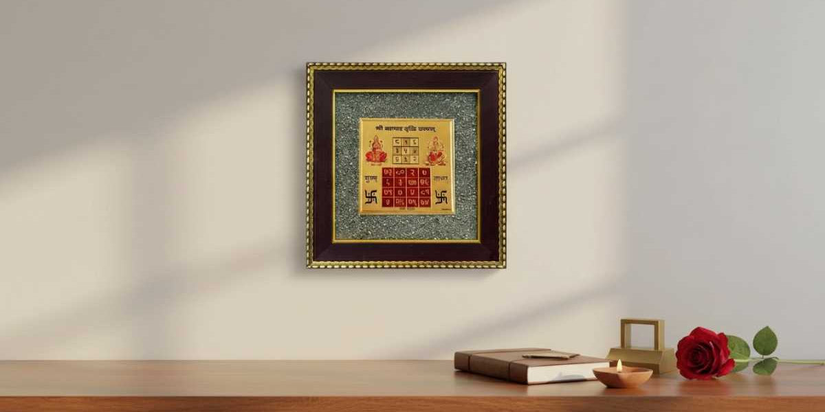 Pyrite frame with Vyapar Vriddhi Yantra on a wall for Vastu, alongside a candle and rose on a wooden desk-Divine Sansar,UAE