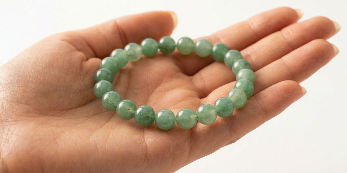 Green aventurine round bead bracelet on palm with Dubai skyline for visa approval - Divine Sansar