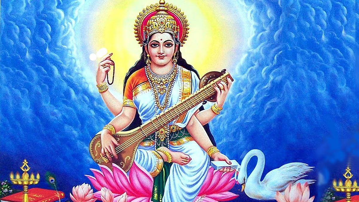 Goddess Saraswati in white and blue seated on a pink lotus playing the veena beside a white swan - Divine Sansar