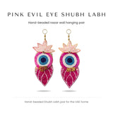 Pink evil eye Shubh Labh hand-beaded wall hanging pair by Divine Sansar