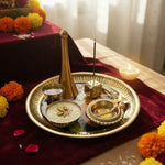 Kamdhenu brass pooja thali set with kheer in katori, lit diya and burning agarbatti in a home mandir - Divine Sansar UAE
