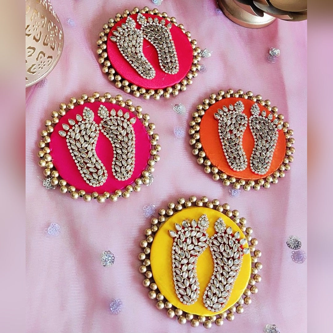 Kundan Laxmi charan discs in pink, orange and yellow on festive fabric - Divine Sansar