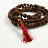 Unpolished 8mm 5 Mukhi Rudraksha beads close up with red tassel - Divine Sansar