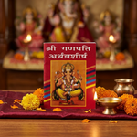 Ganpati Atharvashirsha booklet on pooja altar with diya and marigolds - Divine Sansar