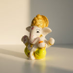 Yellow dhoti Ganesh idol 6 cm shown in natural light on a desk, small Ganesha murti - Divine Sansar