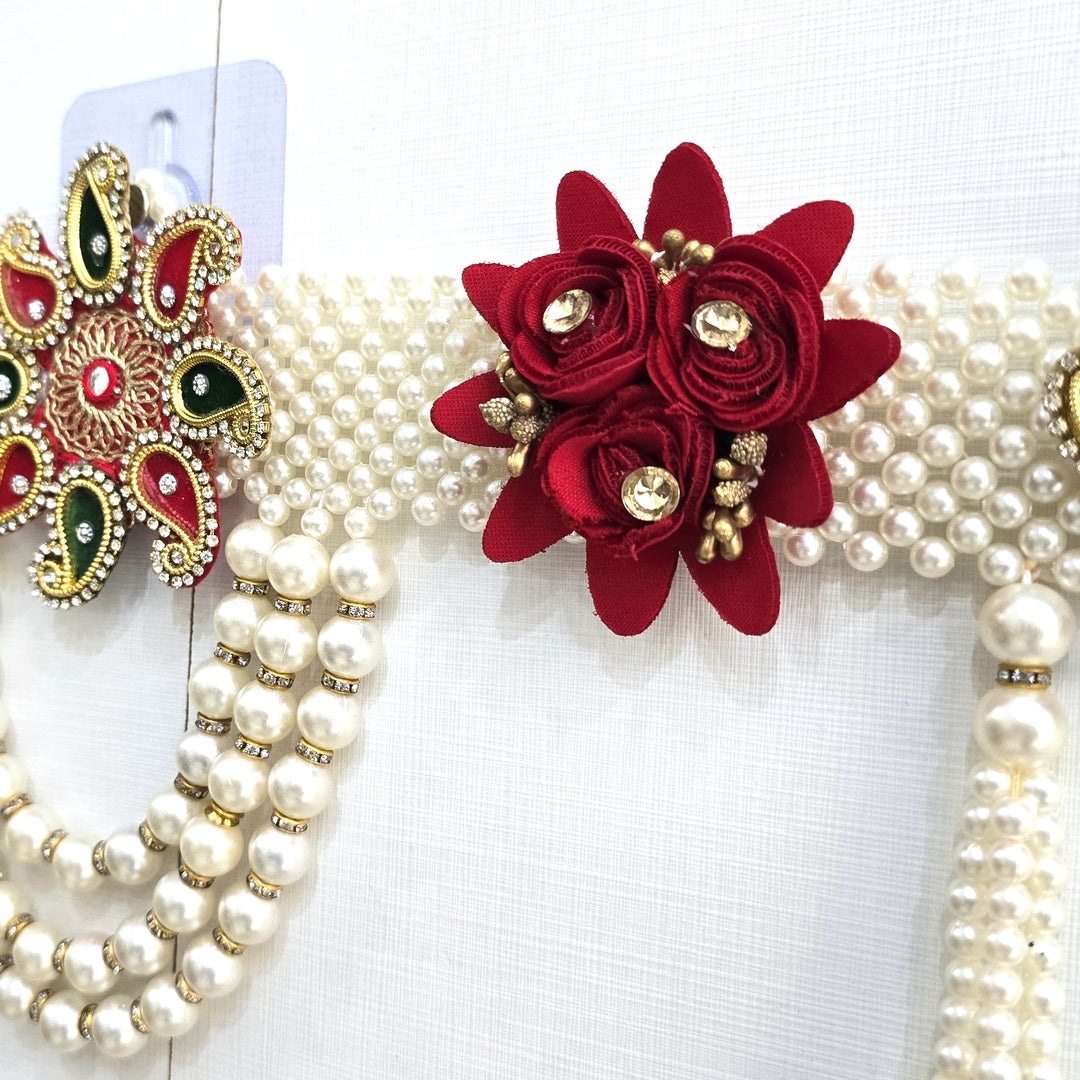 Maroon fabric rose cluster on the woven pearl band of the Divine Sansar toran