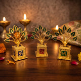 Three golden metal Tulsi plants lit by diyas in a pooja mandir - Divine Sansar