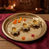 Three lit brass Kamal Diyas on a pooja thali for Diwali and Dhanteras - Divine Sansar