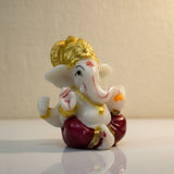 Red dhoti Ganesh idol 6 cm shown on a shelf for home mandir and car dashboard - Divine Sansar
