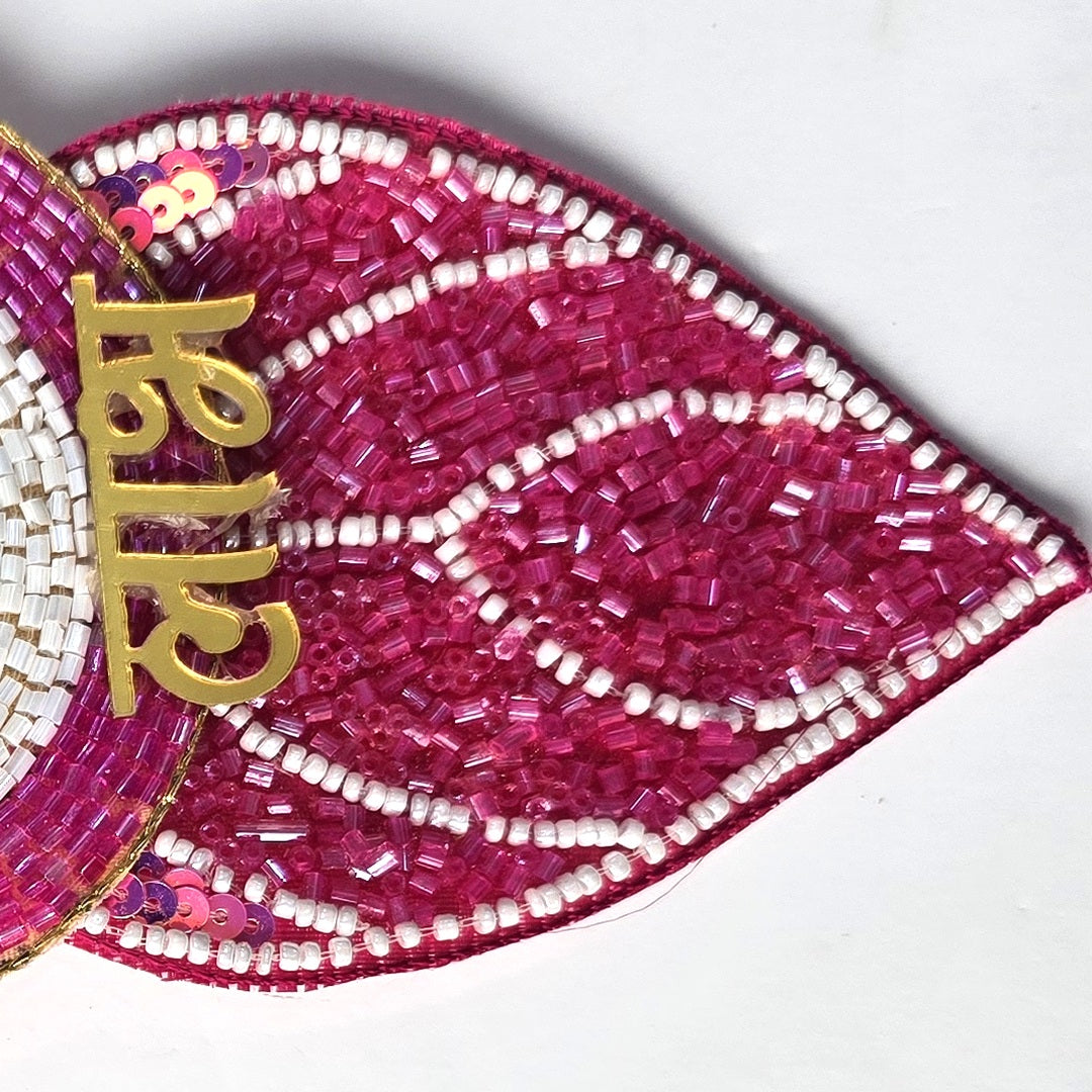 Magenta beaded leaf pendant and gold Devanagari Laabh lettering on the Divine Sansar nazar hanging