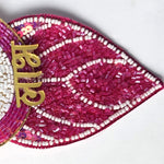 Magenta beaded leaf pendant and gold Devanagari Laabh lettering on the Divine Sansar nazar hanging