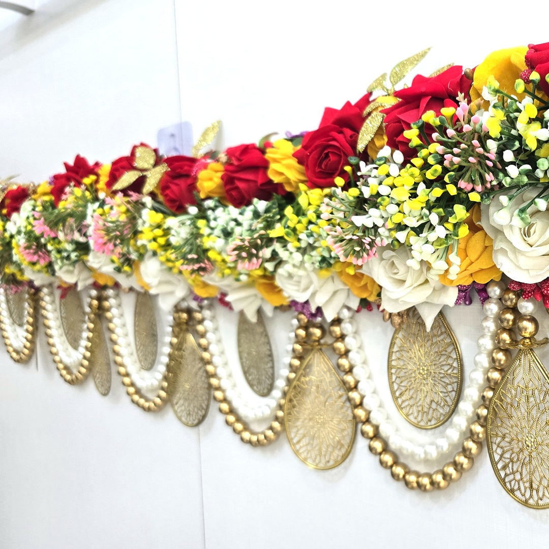 Pearl and antique gold bead swags below the rose bank on the Divine Sansar toran