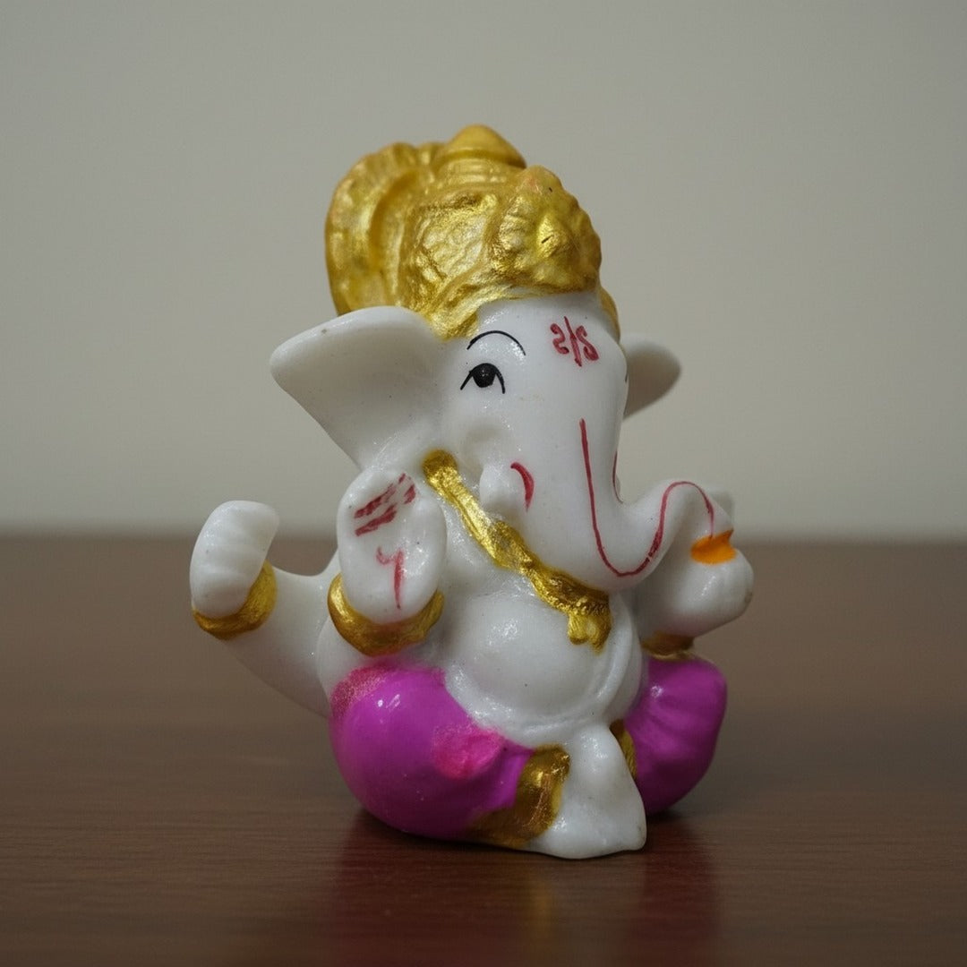 Pink dhoti Ganesh idol 6 cm on a wooden table, hand-painted small Ganesha murti UAE - Divine Sansar