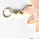 Brass ring hanger with pearl and gold beads on the Divine Sansar pink evil eye Shubh Labh hanging