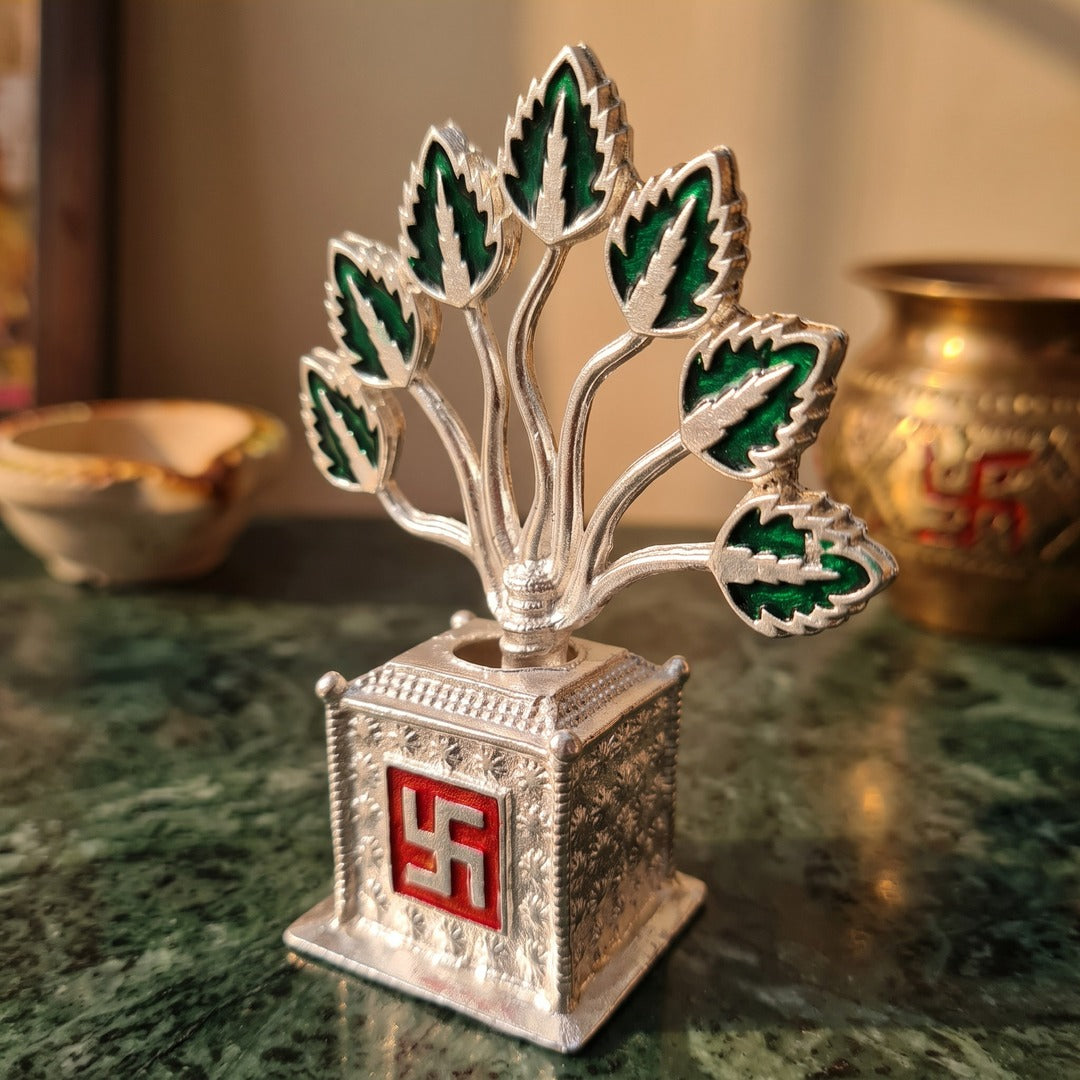 Silver metal Tulsi plant on a green marble pooja shelf - Divine Sansar