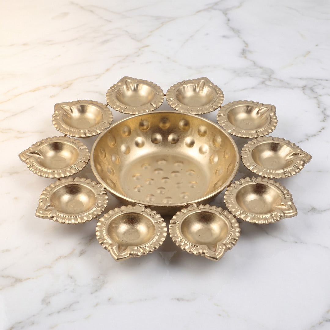 Brass finish 10 diya urli bowl on white marble, Divine Sansar