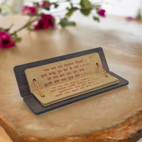 Divine Sansar-A wooden pocket Hanuman Chalisa book stands open on a table, displaying verses written in Hindi.