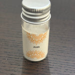 Divine Sansar Avir Powder with a silver cap on a dark wooden surface