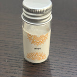 Divine Sansar Avir Powder with a silver cap on a dark wooden surface