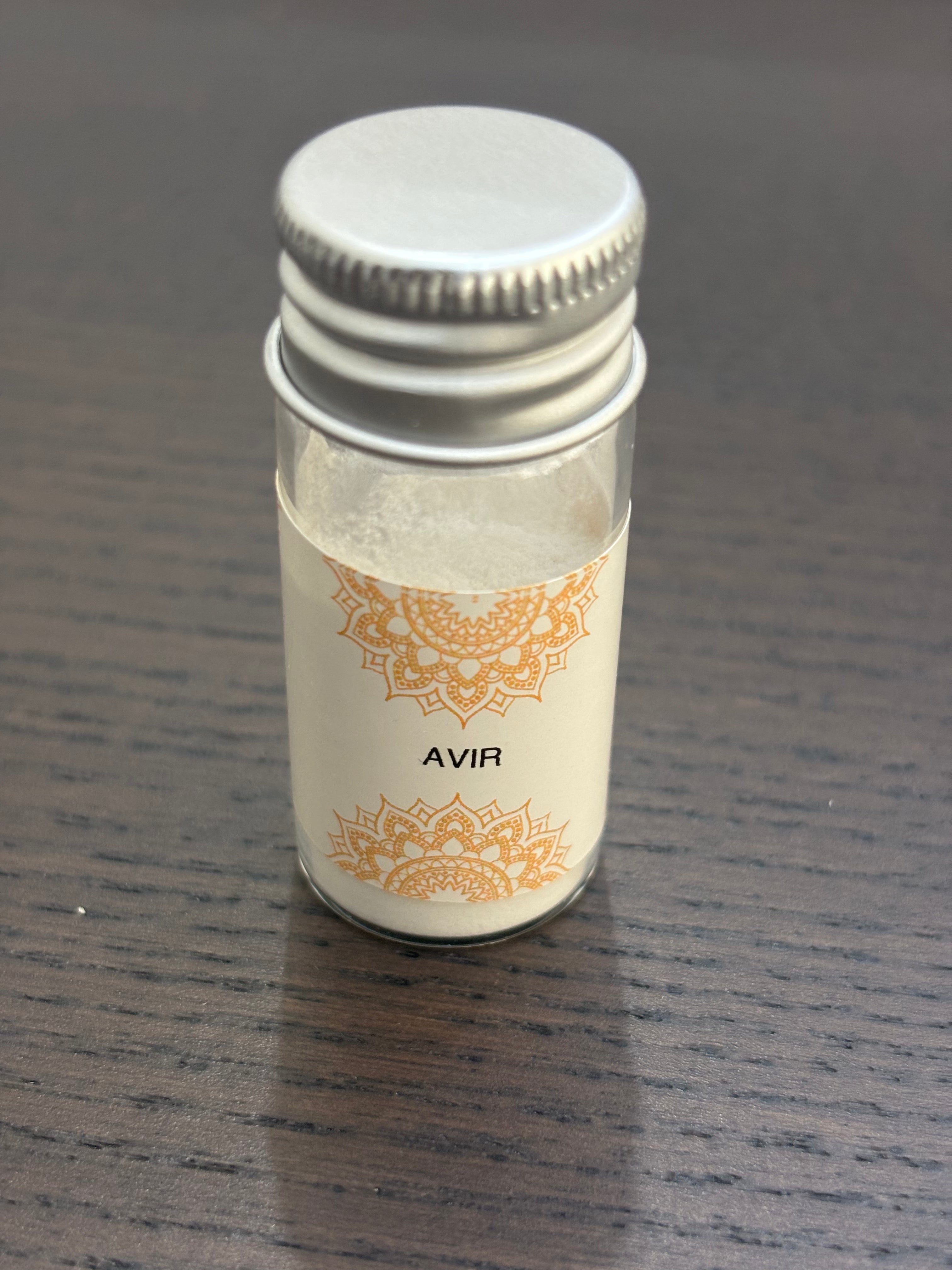 Divine Sansar Avir Powder with a silver cap on a dark wooden surface
