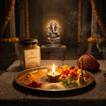 Divine Sansar-Chandan Kesar powder beside Pooja thali with offerings and a statue of Ganesha in the background