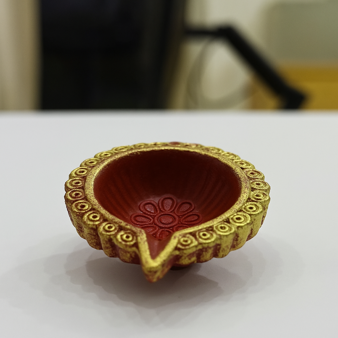 Divine Sansar-Clay Diya decorated with gold rim and red interior on a white surface