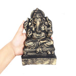 Ganesh idol made with the Make Your Own Ganesh Kit held in one hand for size, painted black and gold after drying - paint is not included in the kit - Divine Sansar