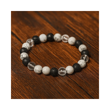 Divine Sansar-Crystal Energy Trinity Bracelet: Howlite · Clear Quartz · Lava-Crystal Energy Trinity bracelet on a wooden surface