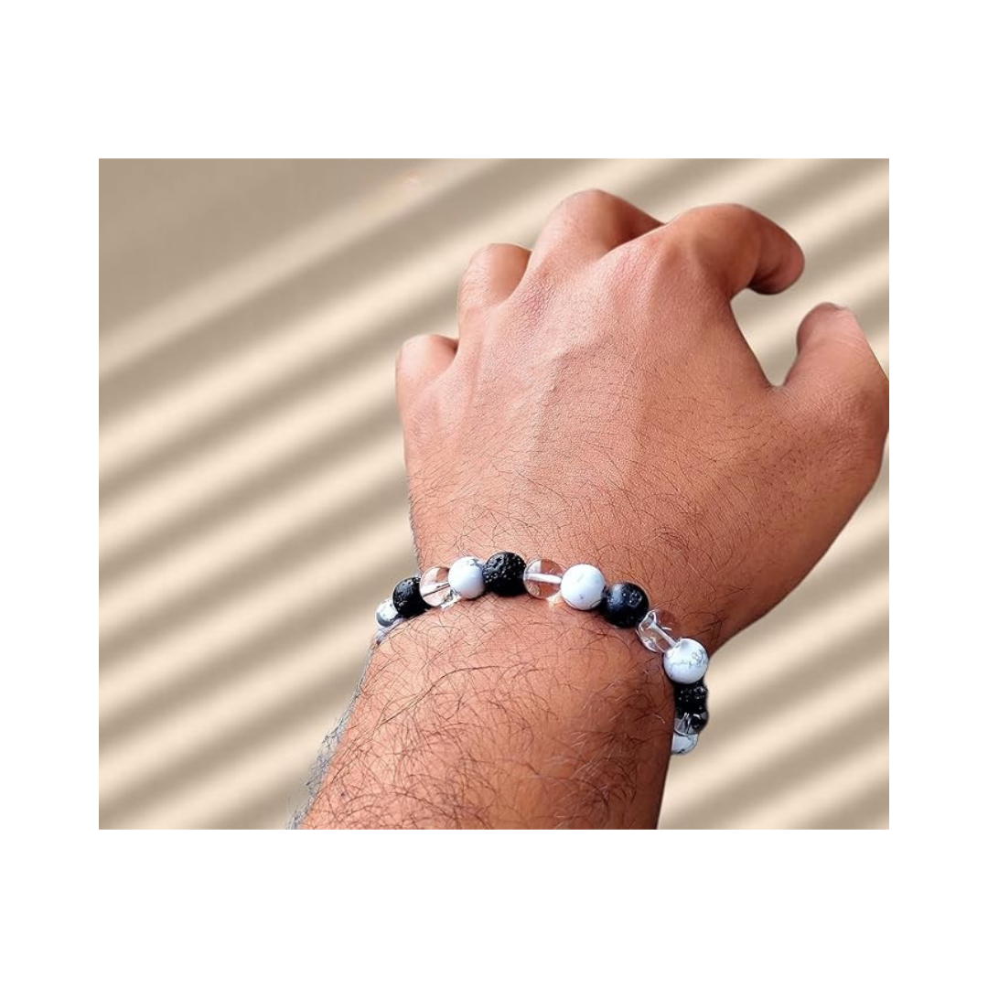 Divine Sansar-Crystal Energy Trinity Bracelet: Howlite · Clear Quartz · Lava-Hand wearing a Crystal Energy Trinity bracelet on a beige background