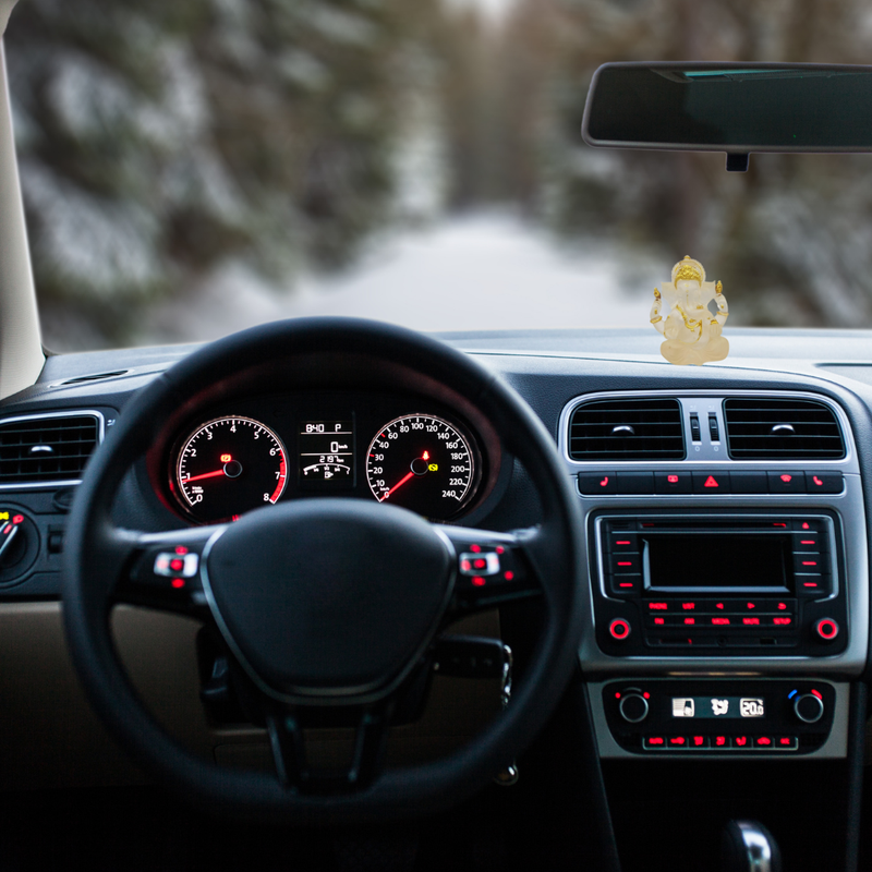 Divine Sansar-Divine Ganesha Statue-Transparent white-4 Inches-Car interior with dashboard lights on, steering wheel, and a small Ganesh Ji on the dashboard.