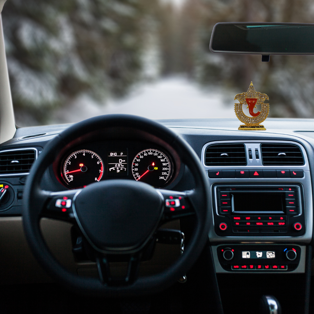 Divine Sansar-Ganpati Idol with Sparkling Stones-Car interior with dashboard and steering wheel, featuring a Ganpati Idol with Sparkling Stones on the dashboard.