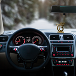 Divine Sansar-Golden Ek Onkar Idol-Car interior with dashboard, steering wheel, and decorative Golden Ek Onkar Idol on a blurred road background