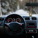 Divine Sansar-Golden Ek Onkar Idol with Sparkling Stones-Car interior with dashboard, steering wheel, and Golden Ek Onkar Idol on a blurred road background