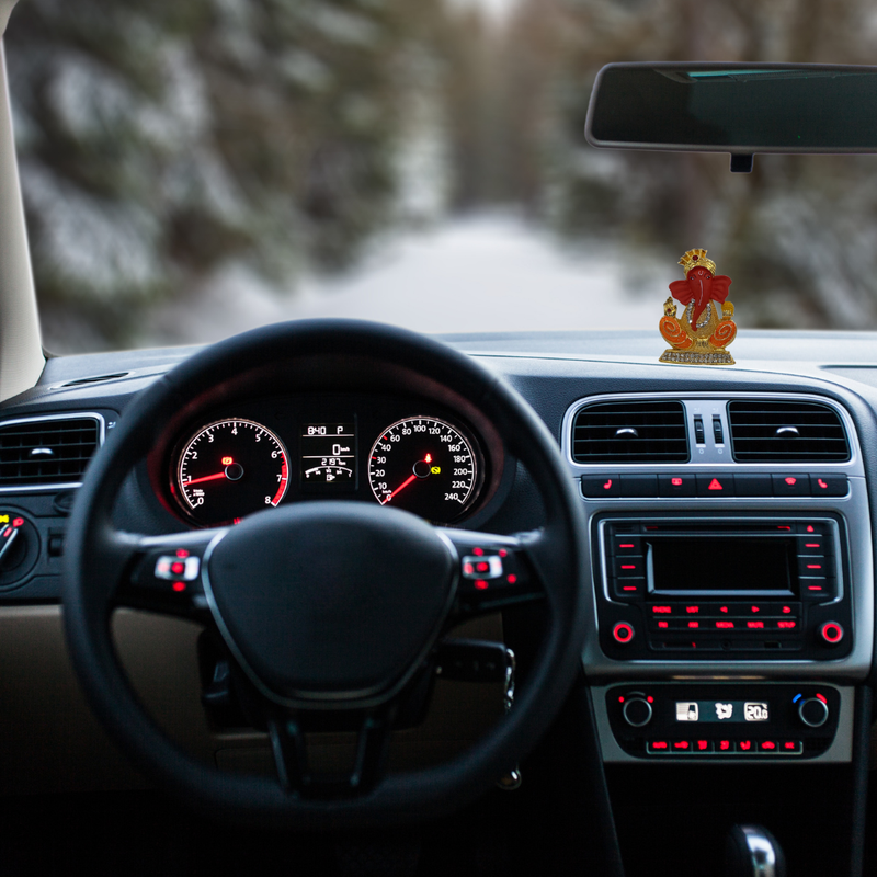 Divine Sansar-Golden Ganpati with Meenakari-Car interior with dashboard, steering wheel, and Golden Ganpati with Meenakarion the dashboard.
