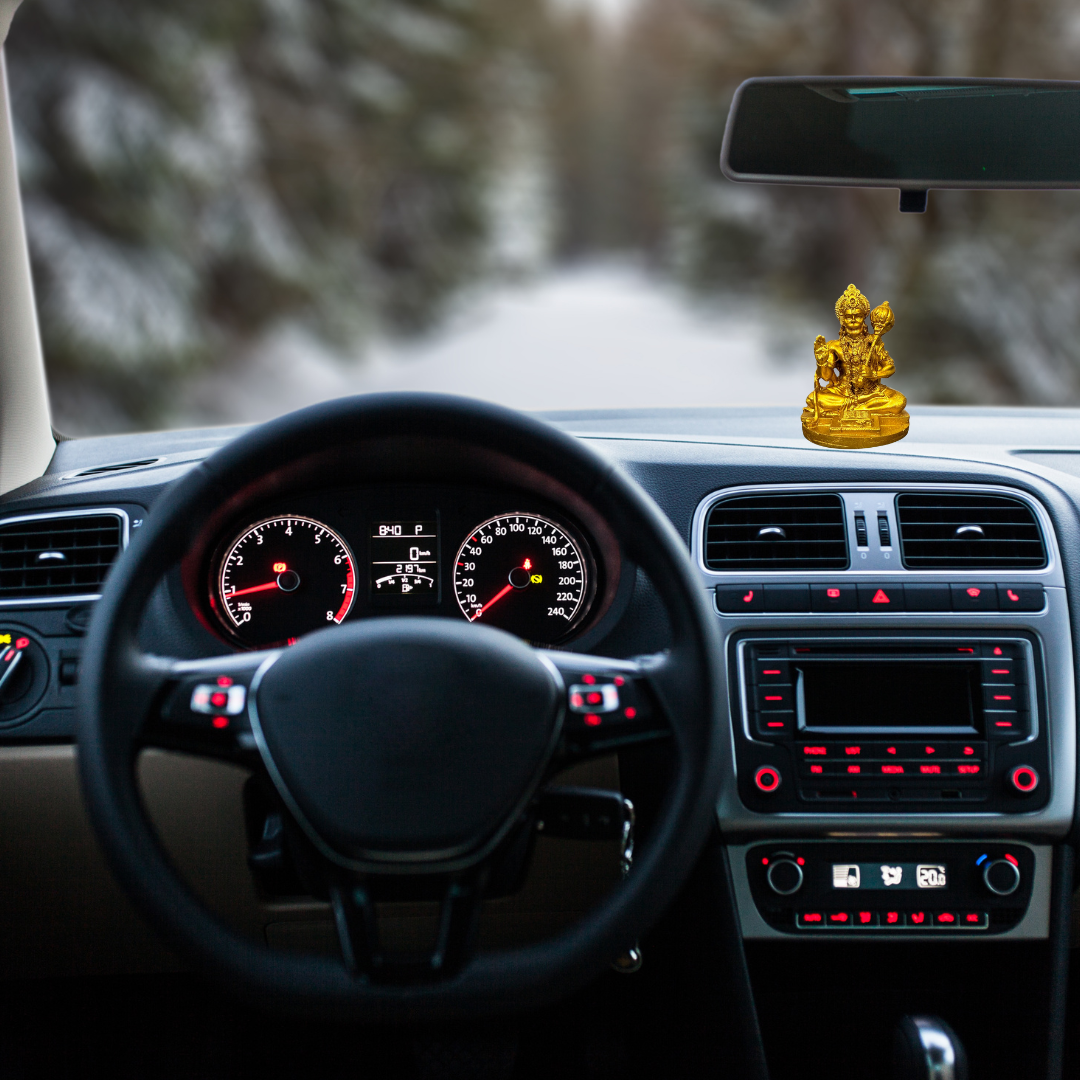 Divine Sansar-Golden Hanumanji Statue-Car interior with a steering wheel and dashboard, featuring Golden Hanumanji Statue on the dashboard.