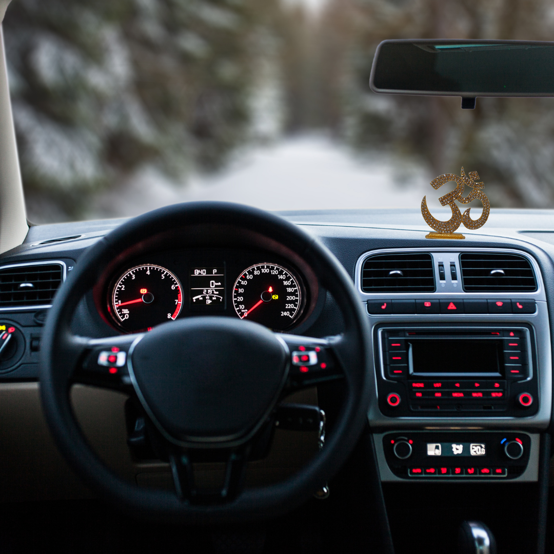 Divine Sansar-Golden Om Symbol Idol with Sparkling Stones-Car interior with dashboard and steering wheel, featuring a Golden Om Symbol Idol on the dashboard.