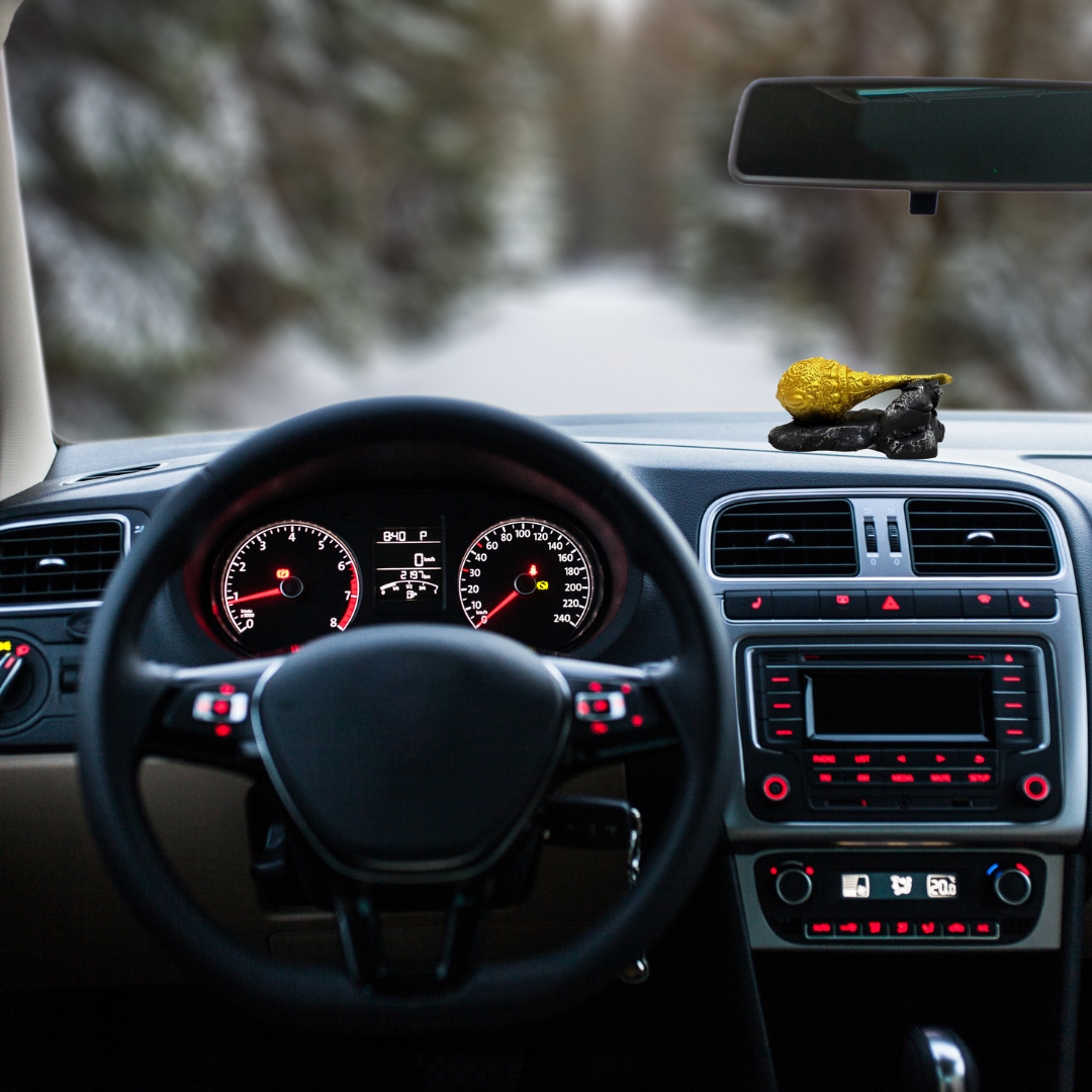 Divine Sansar-Hanumanji Gada-Car interior with dashboard and steering wheel, blurred road in the background