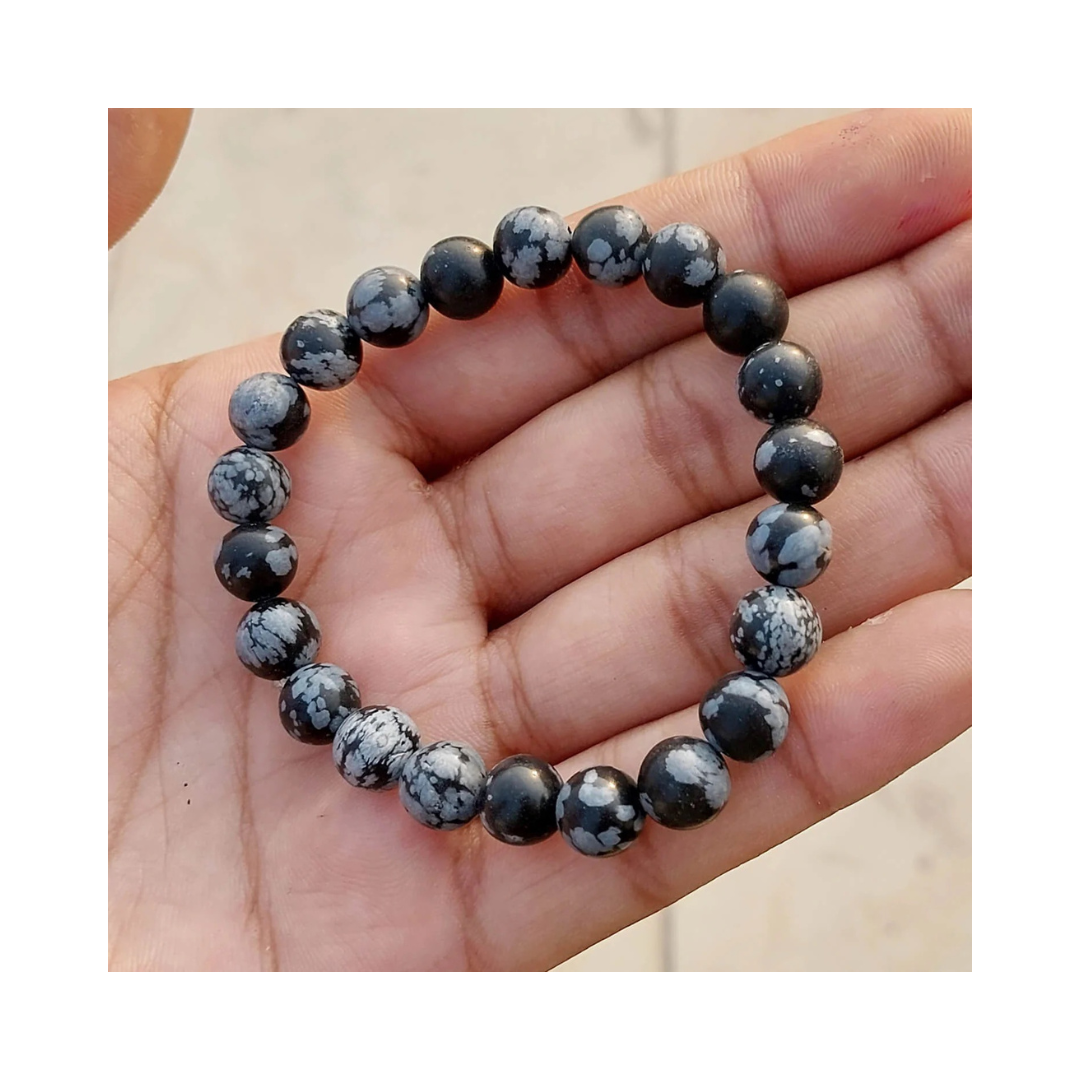 Divine Sansar-InnerPeace Bracelet-Snowflake Obsidian bracelet on a hand against a neutral background