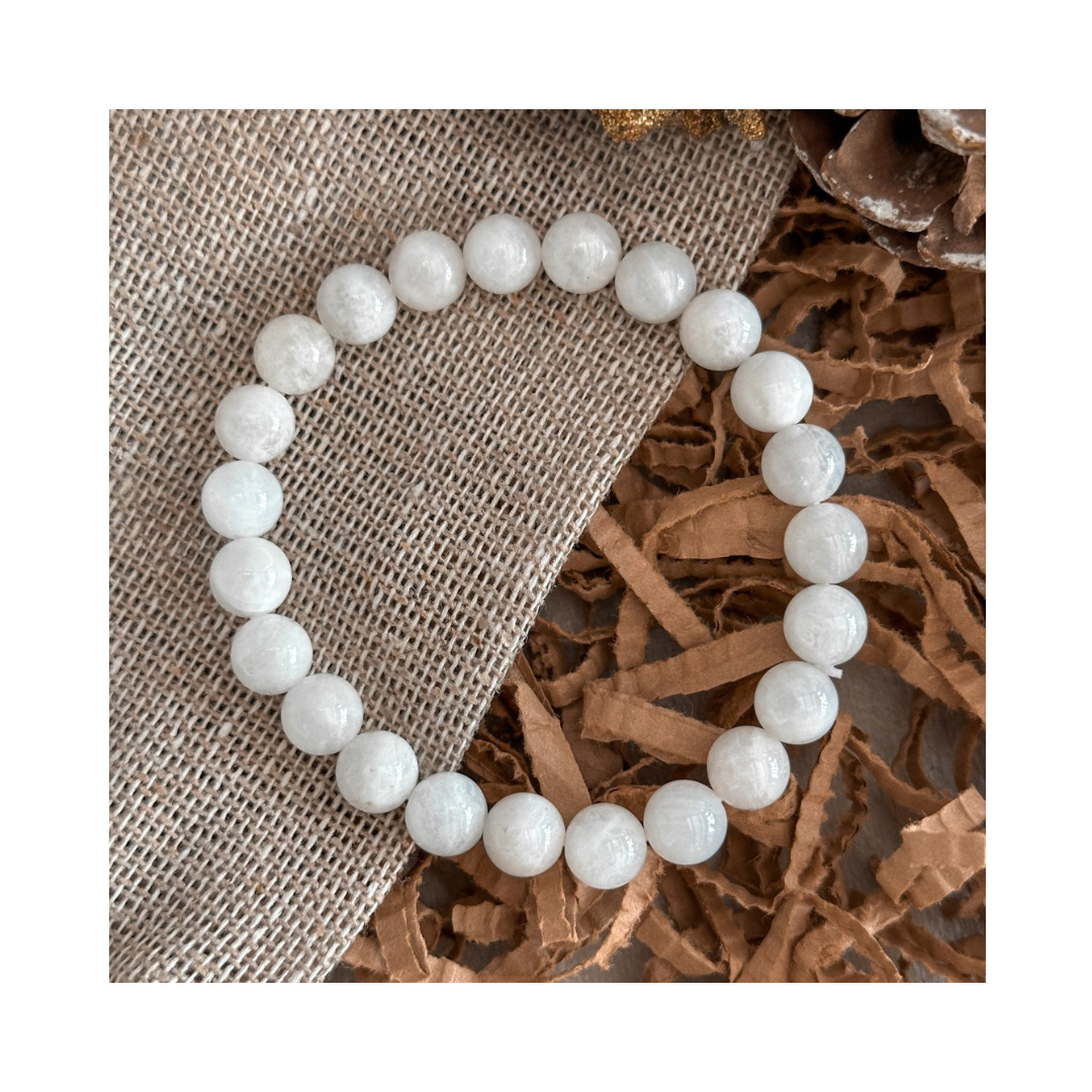 Divine Sansar-LunaGlow Bracelet-Moonstone bracelet on a textured brown surface