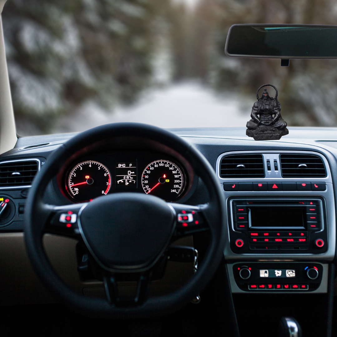 Divine Sansar-Meditating Hanumanji Statue-Car interior with dashboard lights on, steering wheel, and Meditating Hanumanji Statue
on the dashboard.