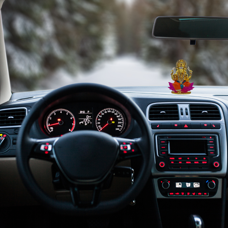 Divine Sansar-Multicolor Golden Ganpati Idol with Sparkling Stones-Car interior with dashboard and steering wheel, featuring a Multicolor Golden Ganpati Idol with Sparkling Stones on the dashboard.