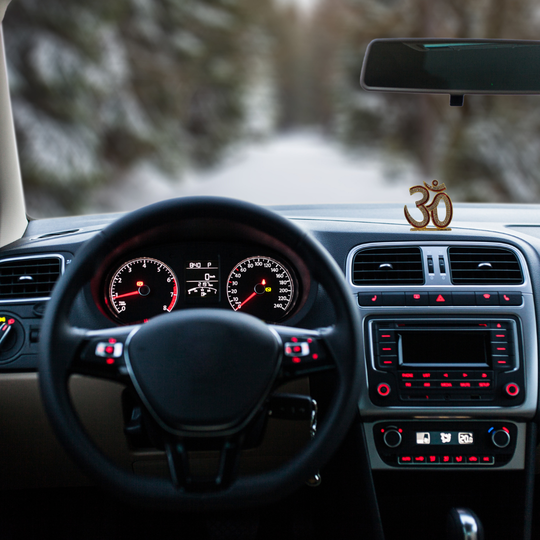 Divine Sansar-Premium Golden Om Idol with Sparkling Stones-Car interior with dashboard and steering wheel, featuring Premium Golden Om Idol on the dashboard.