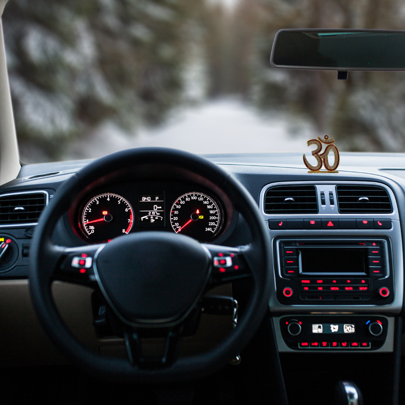 Divine Sansar-Premium Golden Om Idol with Sparkling Stones-Car interior with dashboard and steering wheel, featuring Premium Golden Om Idol on the dashboard.