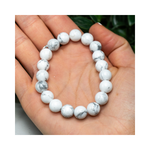 Divine Sansar-Soothing Bracelet: Howlite bracelet on a hand with a blurred green background