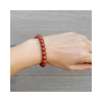 Divine Sansar-Stability Bracelet-Red Jasper bracelet on a wrist against a neutral background