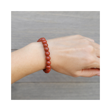 Divine Sansar-Stability Bracelet-Red Jasper bracelet on a wrist against a neutral background