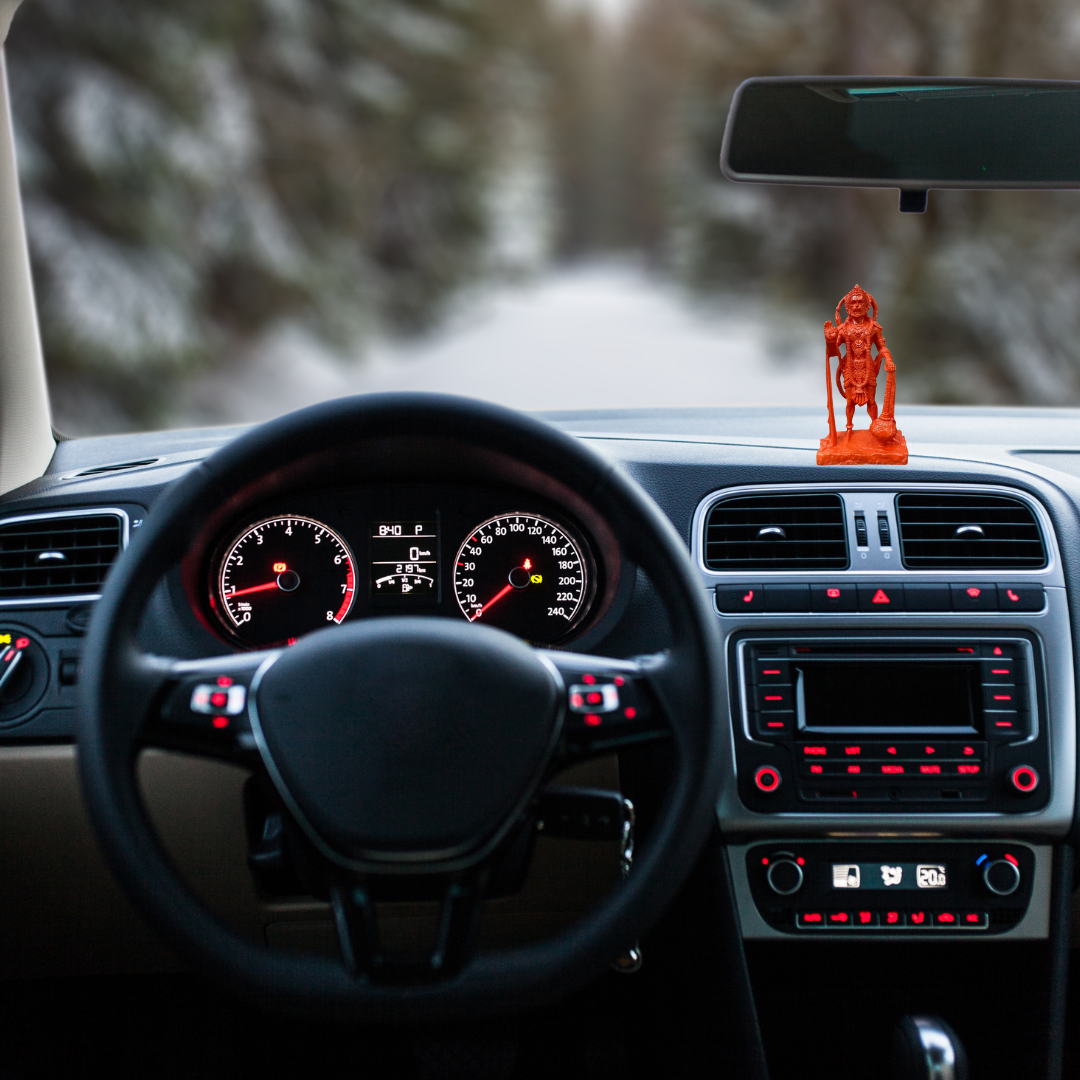 Divine Sansar-Standing Hanumanji Statue-Car dashboard with a steering wheel, dashboard lights, and Standing Hanumanji Statue on the windshield.
