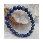 Divine Sansar-WisdomBracelet-LapisLazuli bracelet on a textured white surface with a crystal rock in the background