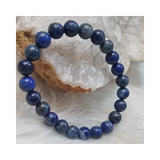 Divine Sansar-WisdomBracelet-LapisLazuli bracelet on a textured white surface with a crystal rock in the background