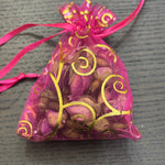 Divine Sansar- a small, pink organza gift pouch filled with dried rose buds.